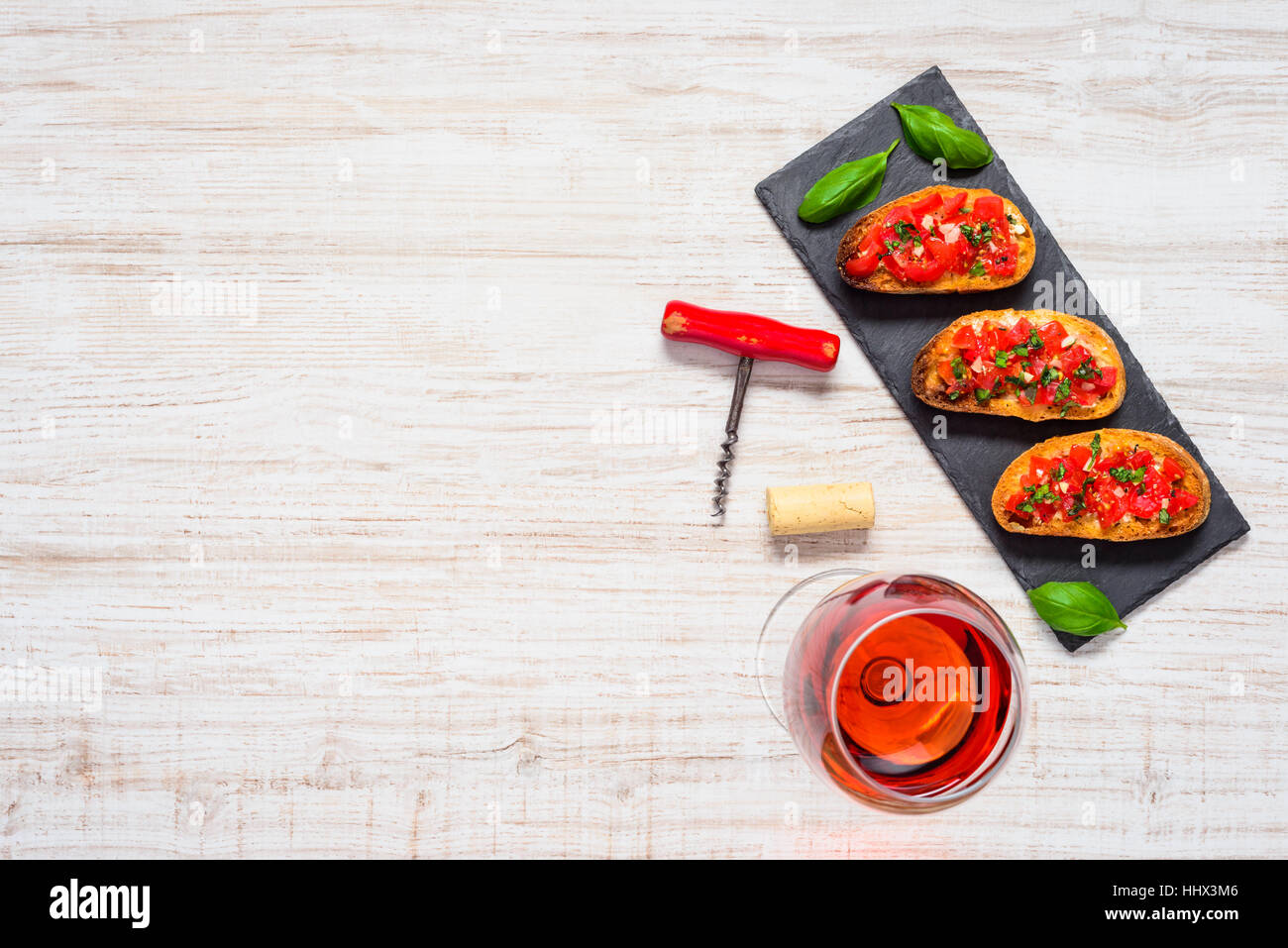 Top View of Bruschetta with tomato, garlic and Basil with a Glass of Rose Wine and on Copy Space Text Area Stock Photo