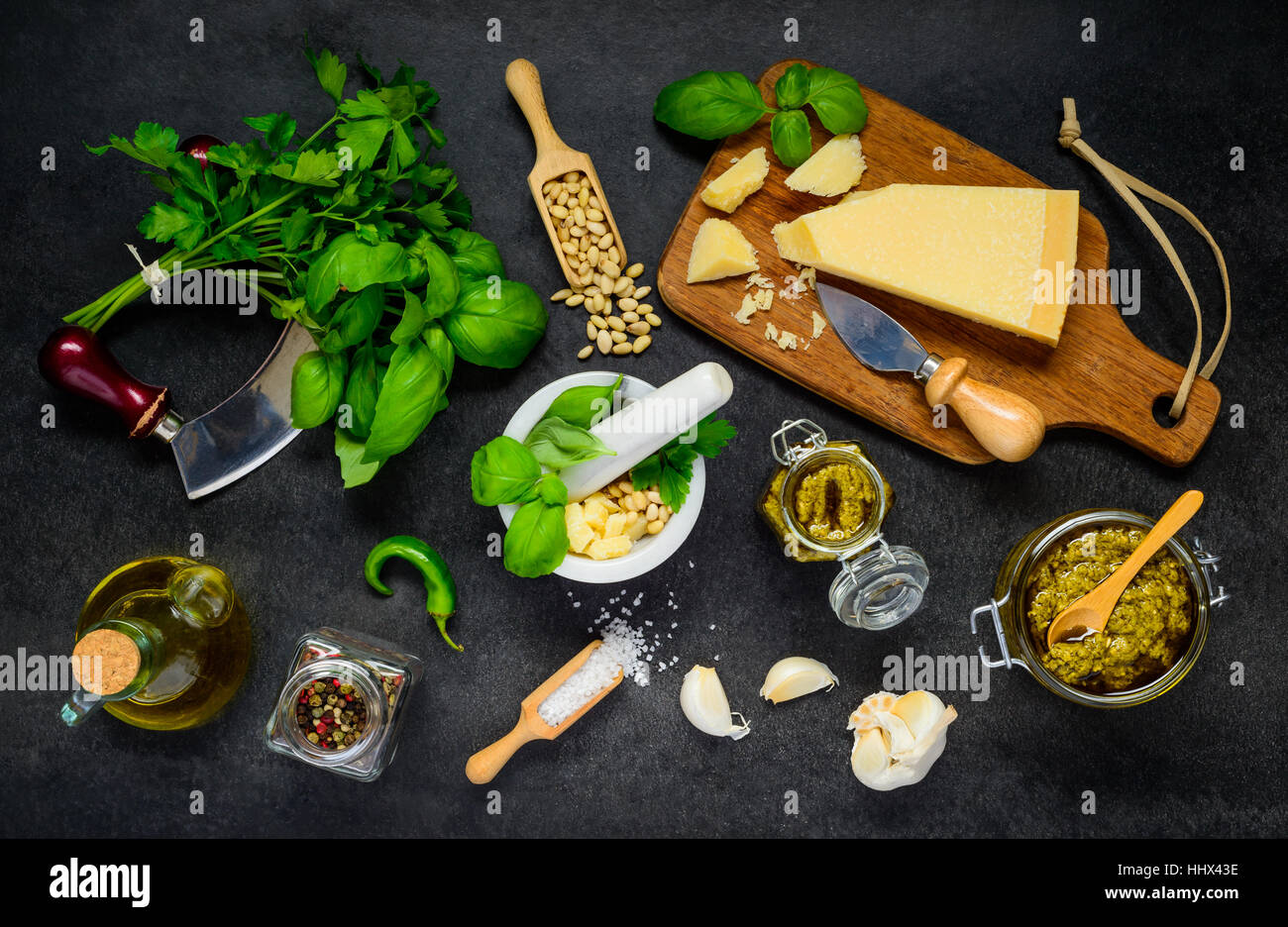 Top View of Parmesan Cheese with Pine Nuts, Pesto and other Cooking Ingredients Stock Photo