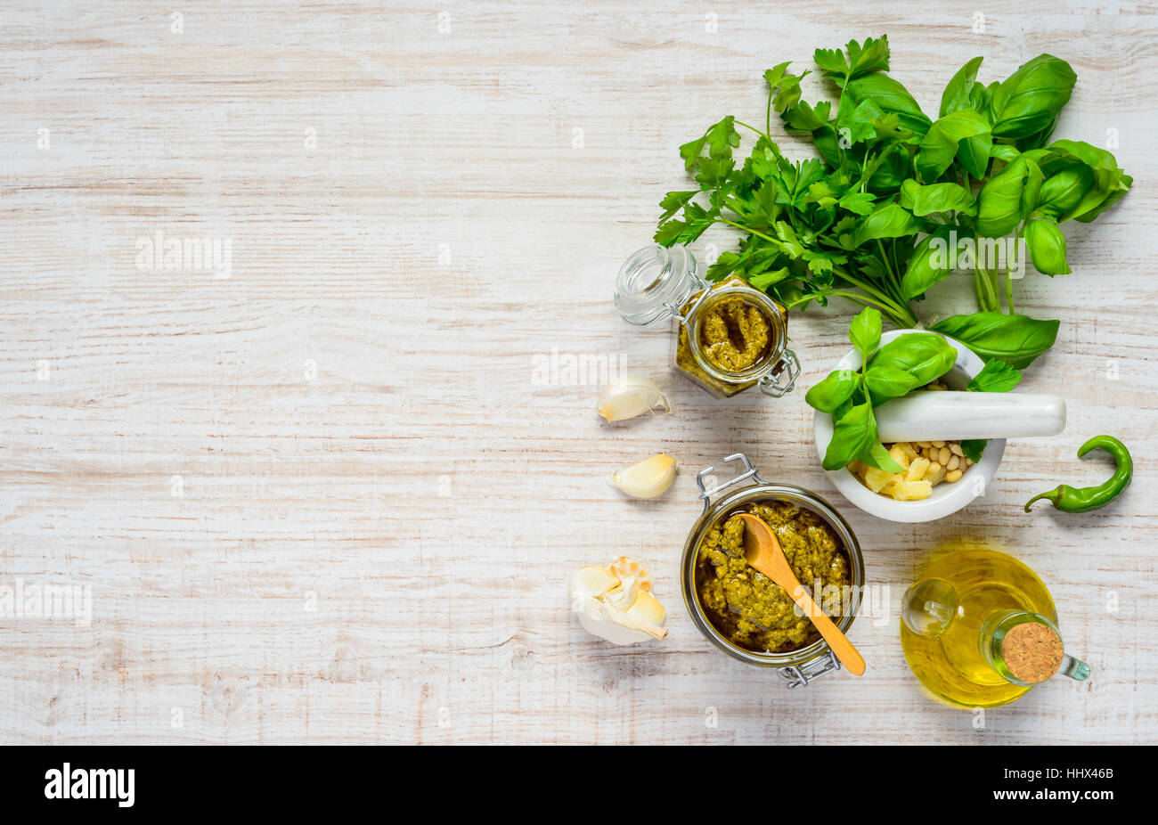 Top View of Pest in Jar with Fresh Green Herbs and Cooking Ingredients and on Copy Space Area Stock Photo