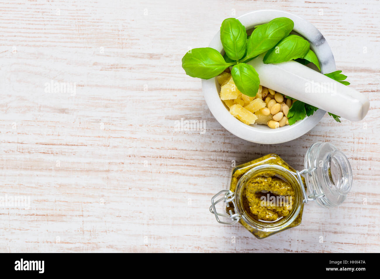 Top View of Copy Space Area with Pesto and Pestle with Mortar and Green Fresh Basil with Parmesan and Pine Nuts Stock Photo