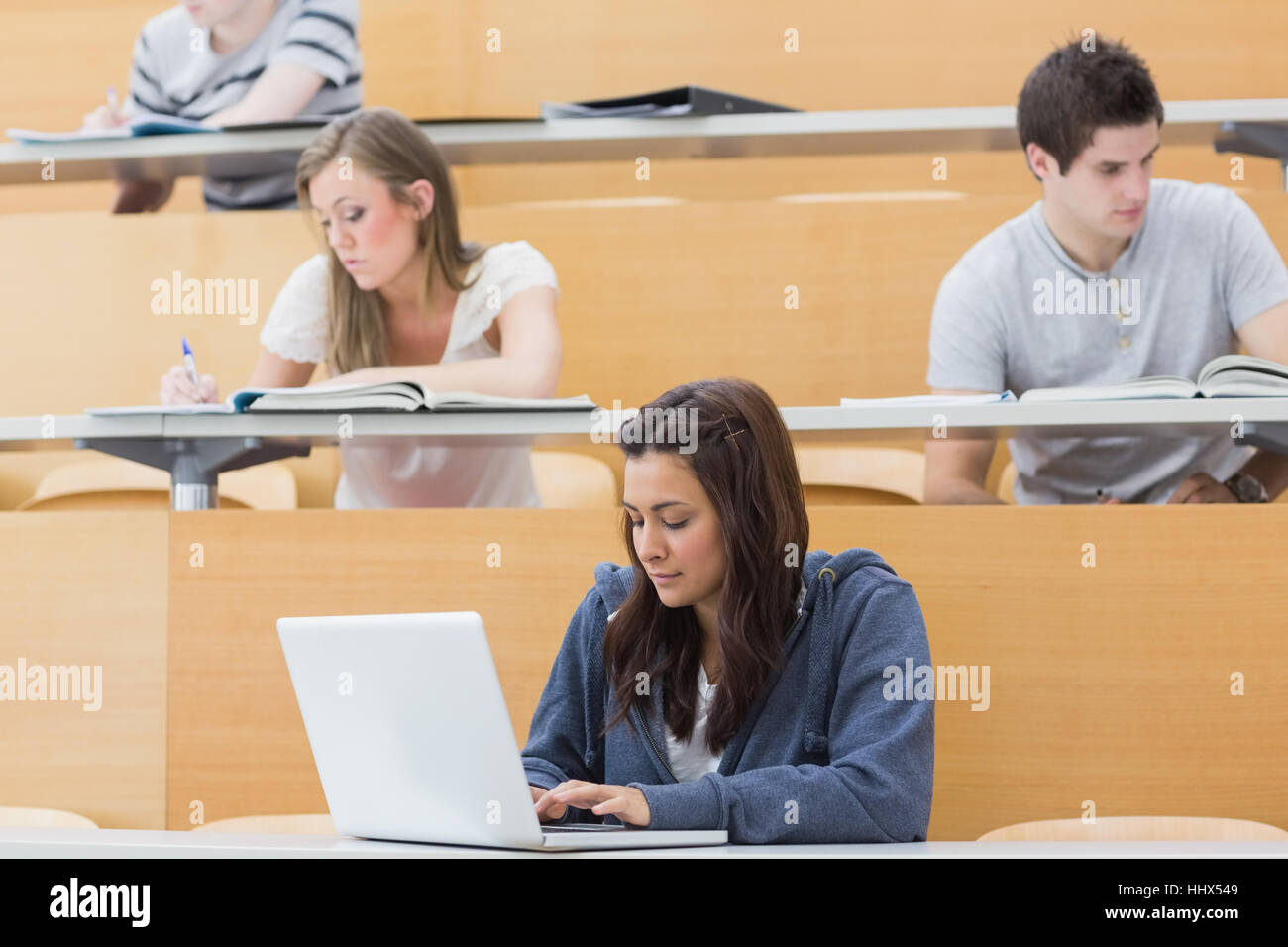 Taking Notes In Lecture Students in a lecture hall taking notes with one using laptop Stock ...