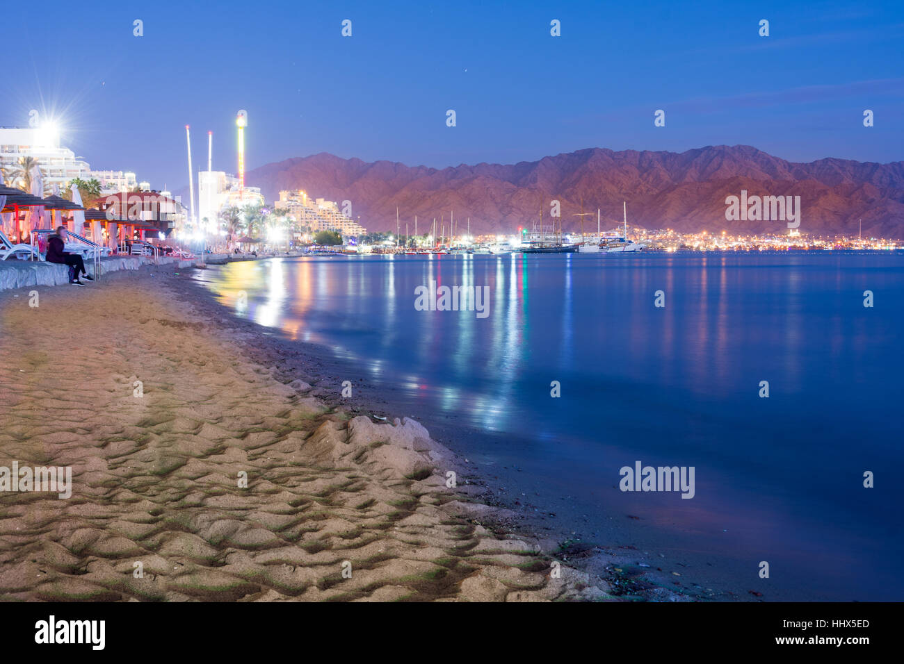 Sunset over the twin cities of Eilat, Israel and Aqaba, Jordan and the Red  Sea Gulf of Aqaba, with the red Aqaba Mountains in the back. People enjoyi  Stock Photo - Alamy