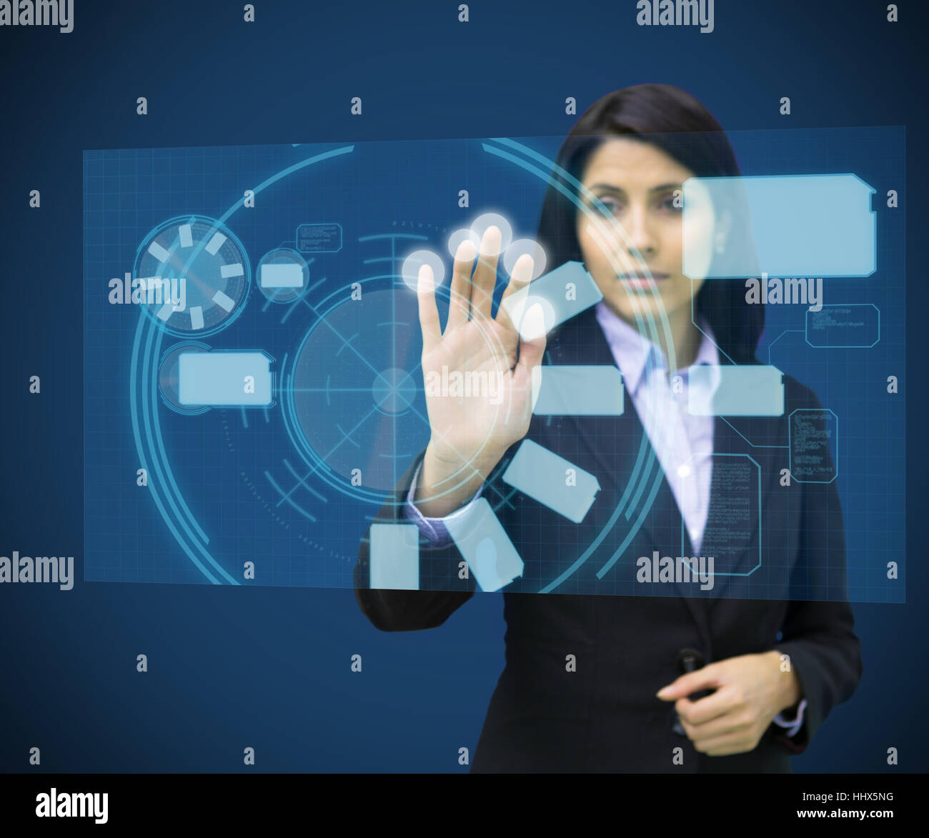 Concentrate woman touching a hologram against blue background Stock ...