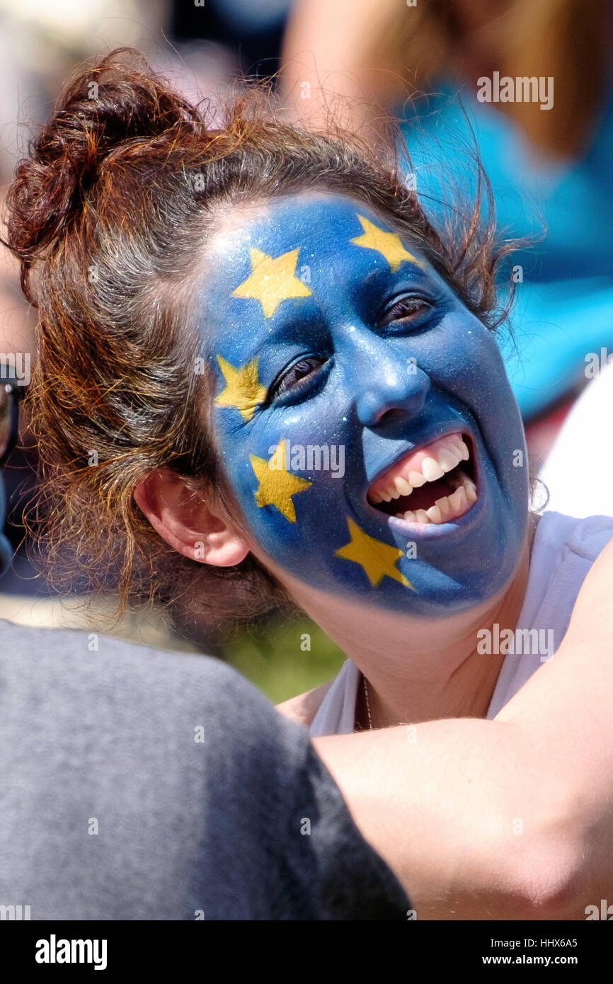Woman with her face painted as the EU flag relaxes after the March for Europe Stock Photo
