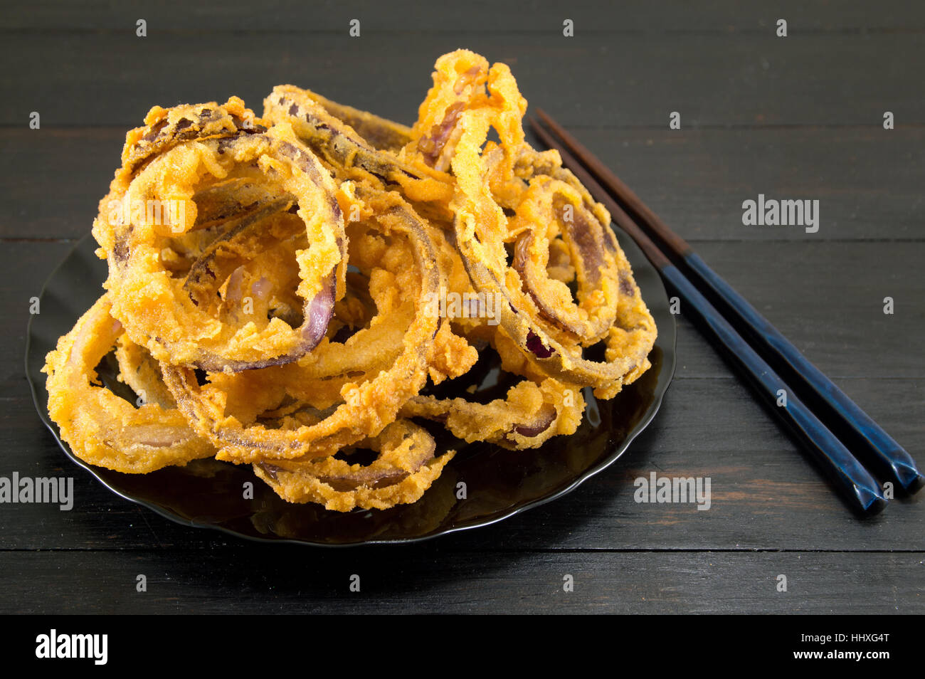 homemade beer battered onion rings with chopsticks Stock Photo