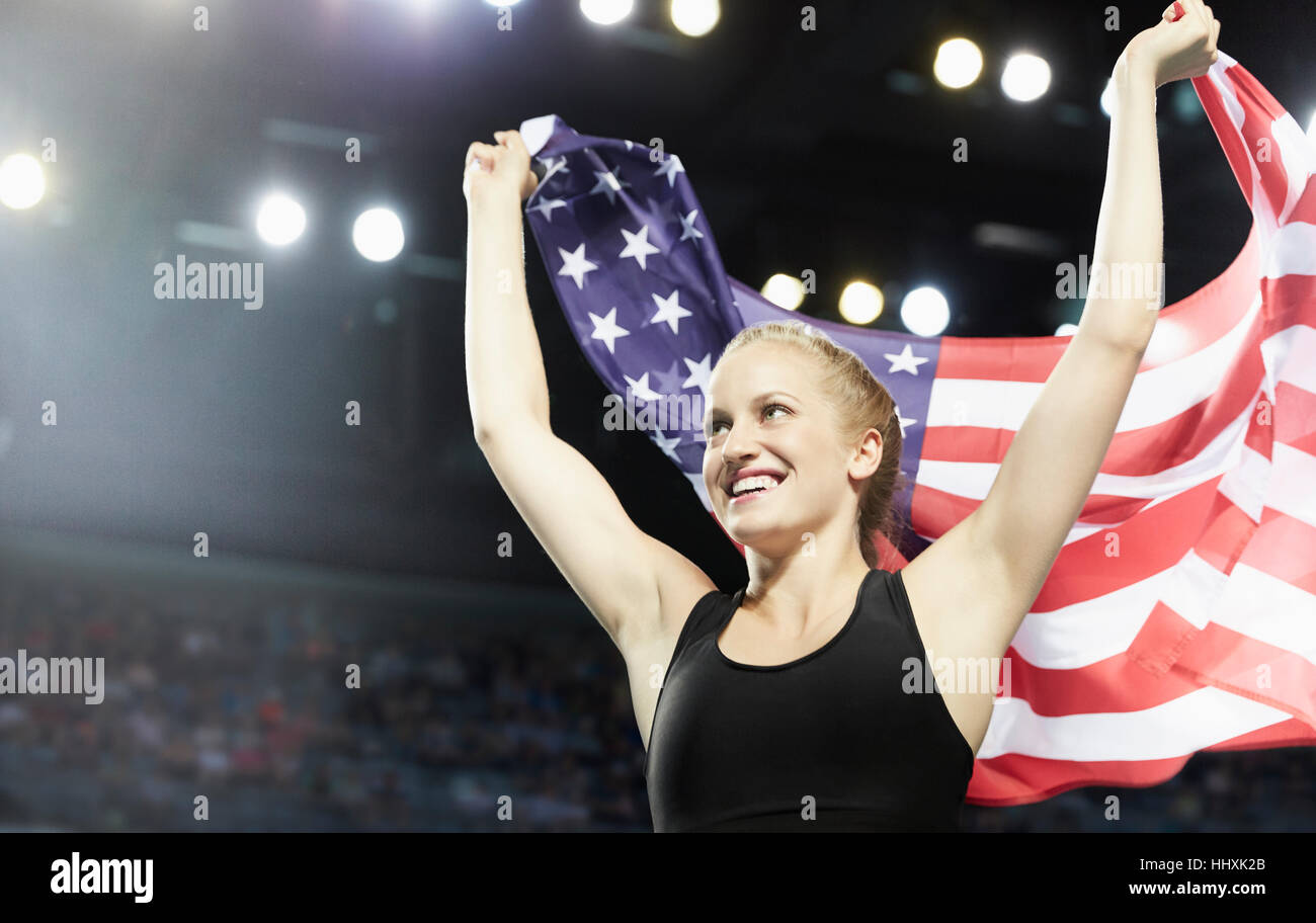 Smiling female runner running victory lap with American flag Stock Photo