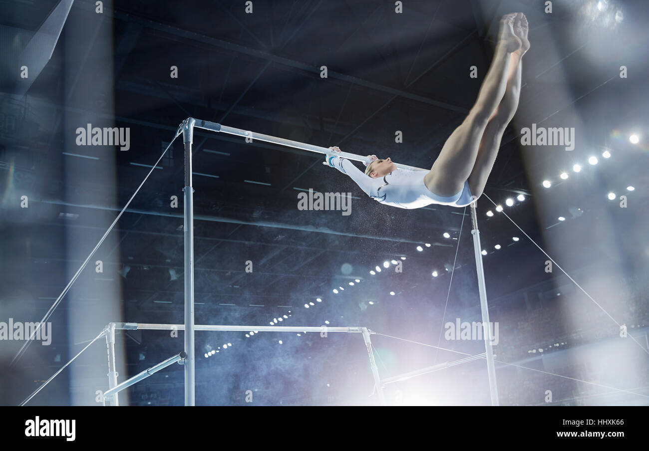 Female gymnast performing on uneven bars in arena Stock Photo Alamy