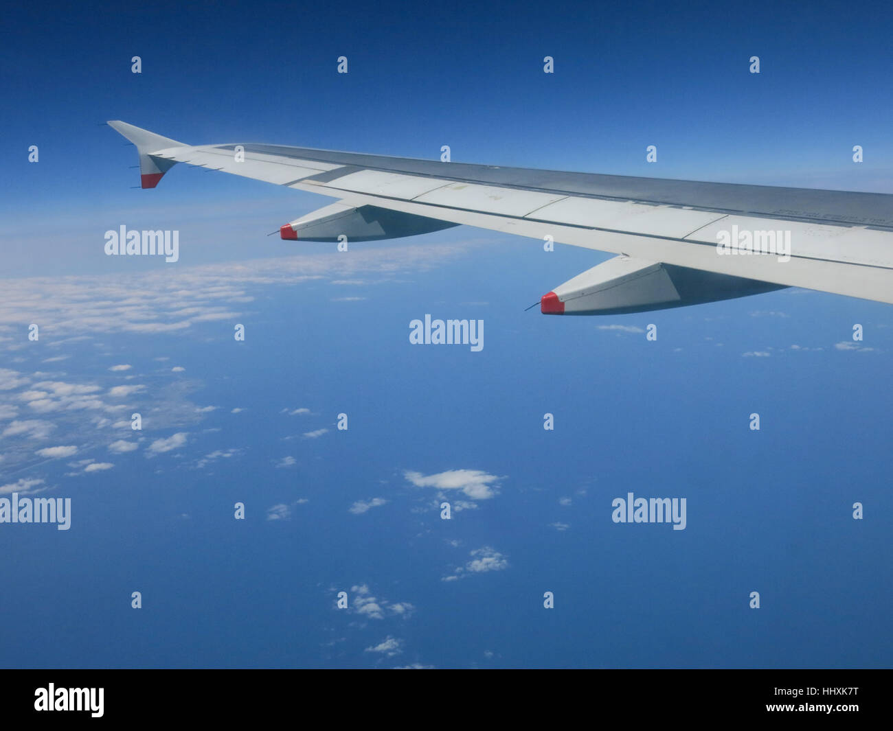 Wing of an aircraft flying over the ocean Stock Photo