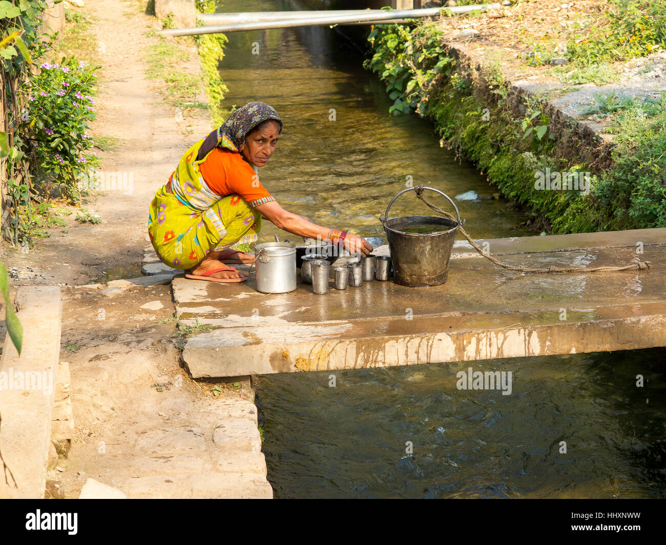 Inabitants of Chotti Haldwani the Jim Corbett village washing dishes at the Boar canal constructed by Sir Henry Ramsay in 1860 Stock Photo