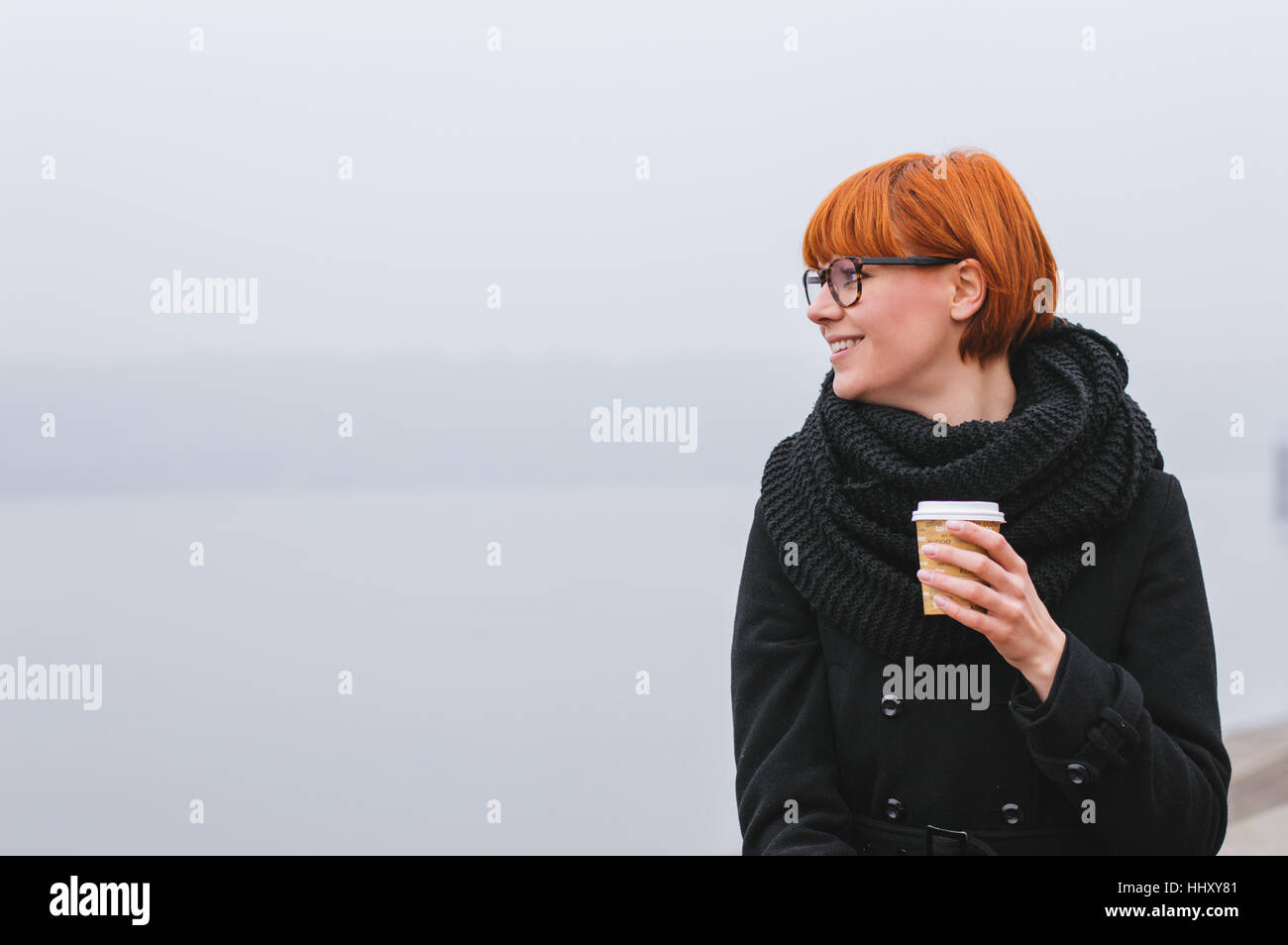 Happy smiling adult tourist girl holding paper coffee cup and enjoying the city Stock Photo