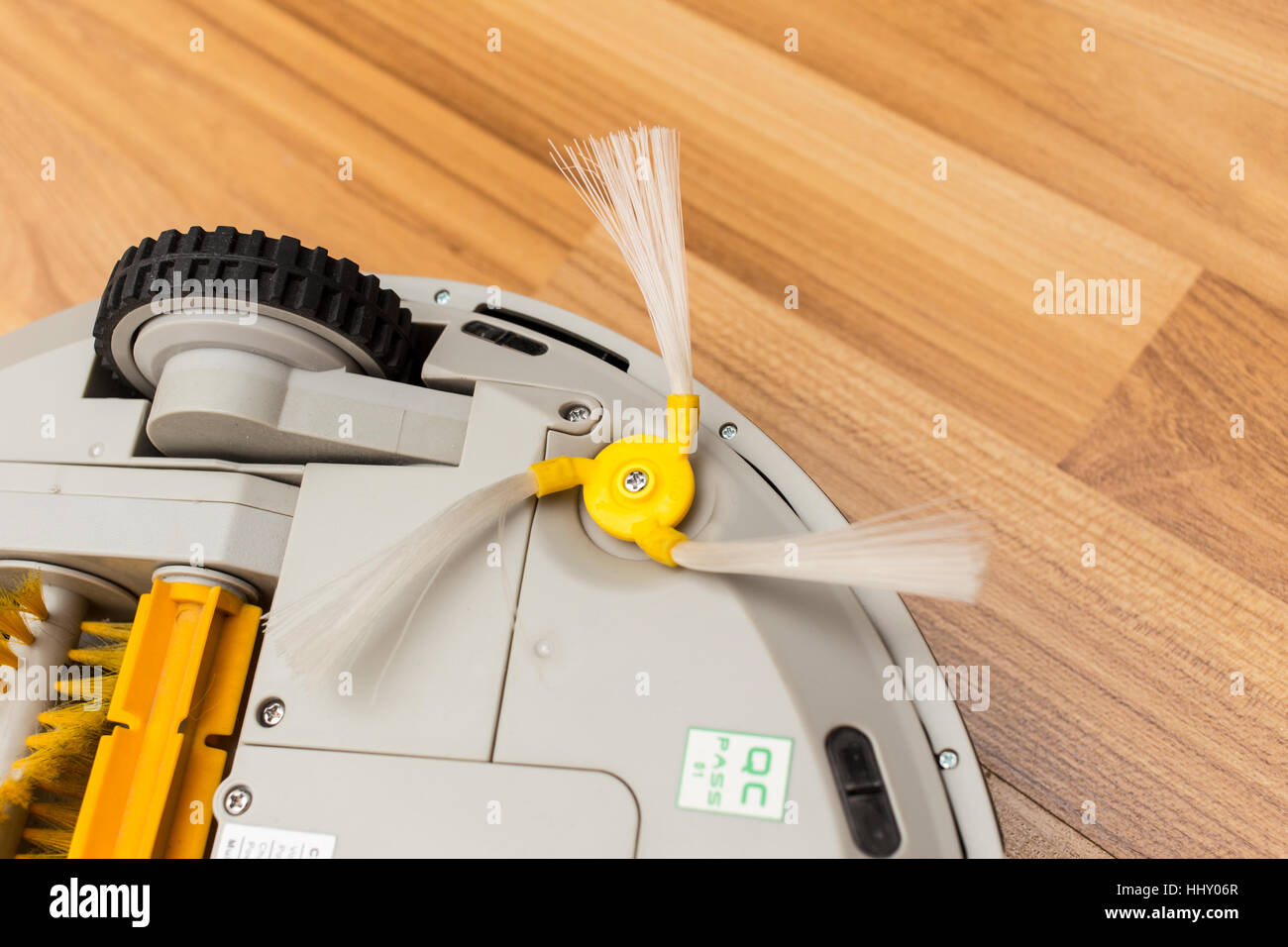 Robotic vacuum cleaner on wood parquet floor, Smart vacuum, new automate technology housework - Part side dust brush. Stock Photo