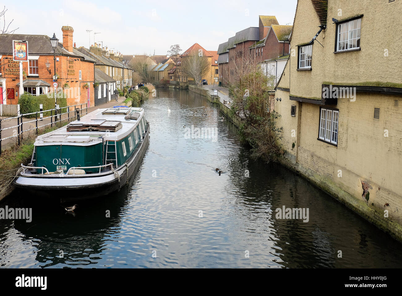 A barge moored on a canal by a country pub in Hertford, England Stock Photo
