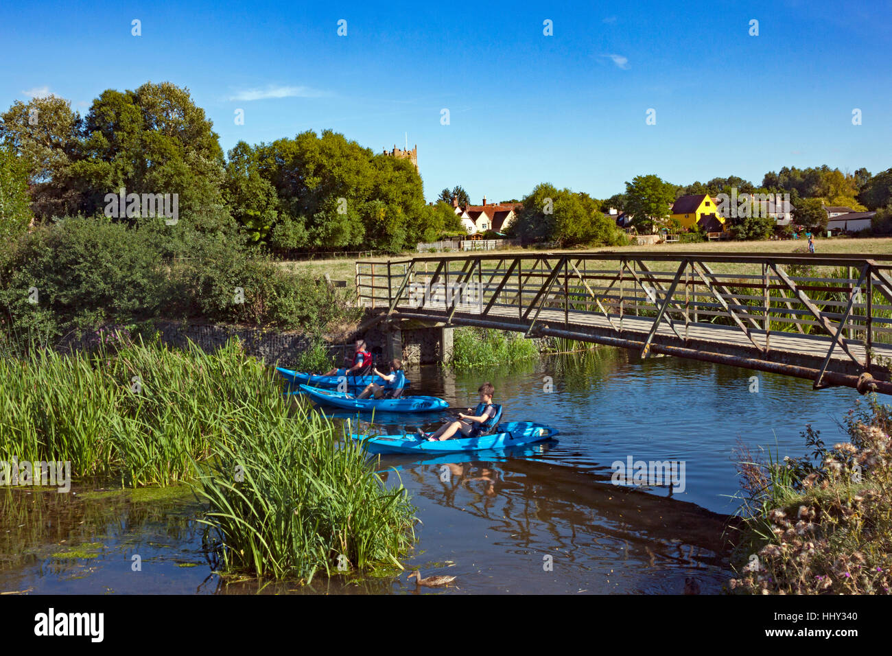 Kayaks passing under a footbridge over the river Stour in Sudbury Meadows, Suffolk Stock Photo