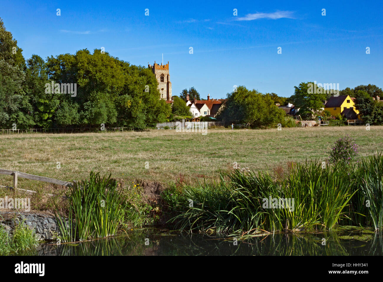 Banks of the river Stour as it flows through Sudbury Meadows, the the tower of All Saints Church in the background. Suffolk Stock Photo