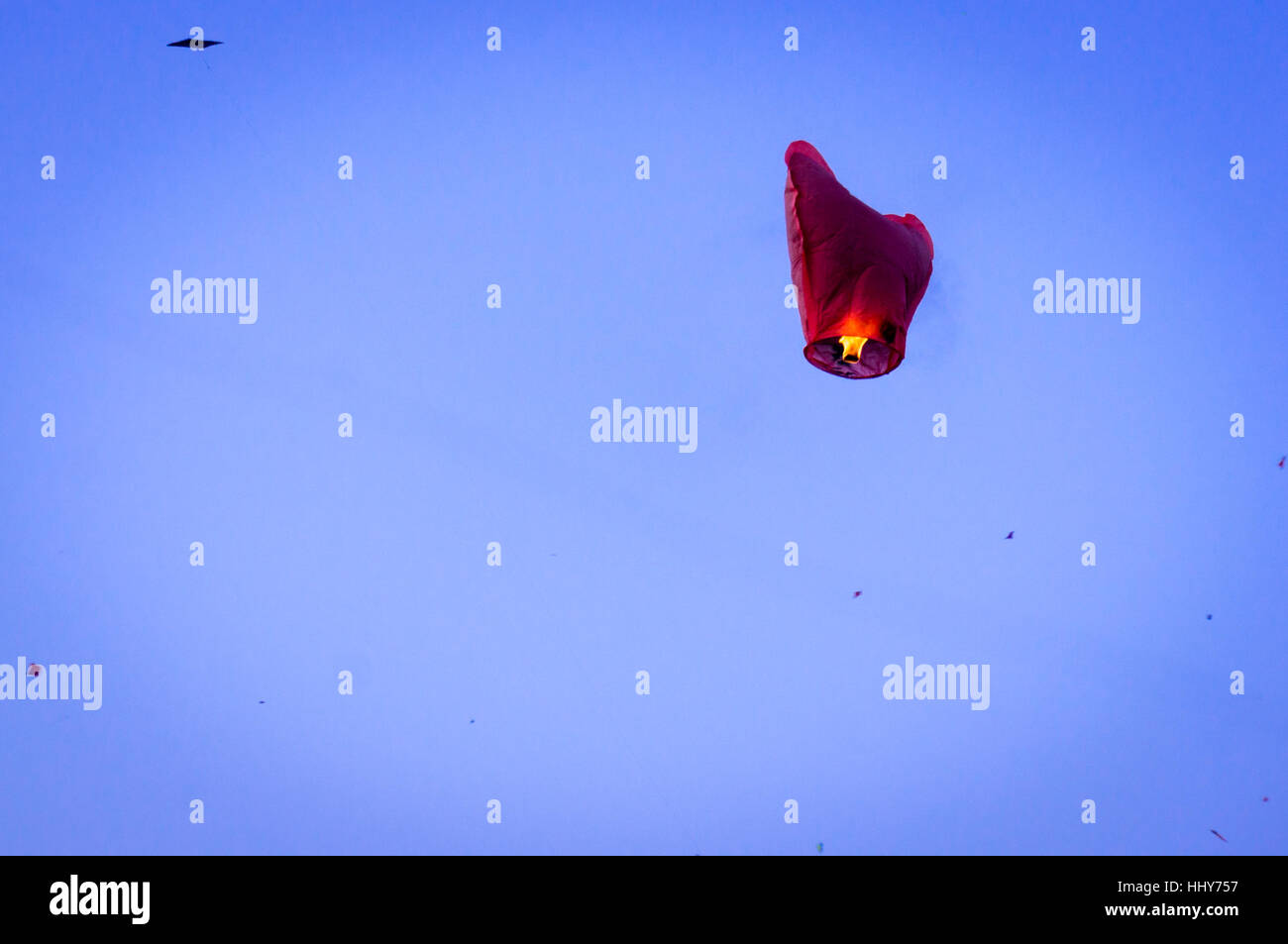 Chinese lantern floats against a blue sky with kites flying against it during the festival of Makar Sankranti in Jaipur India Stock Photo
