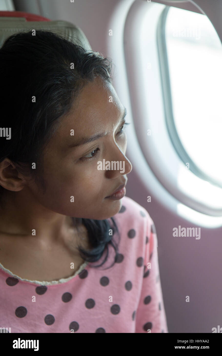 woman looks out the window of an airplane Stock Photo