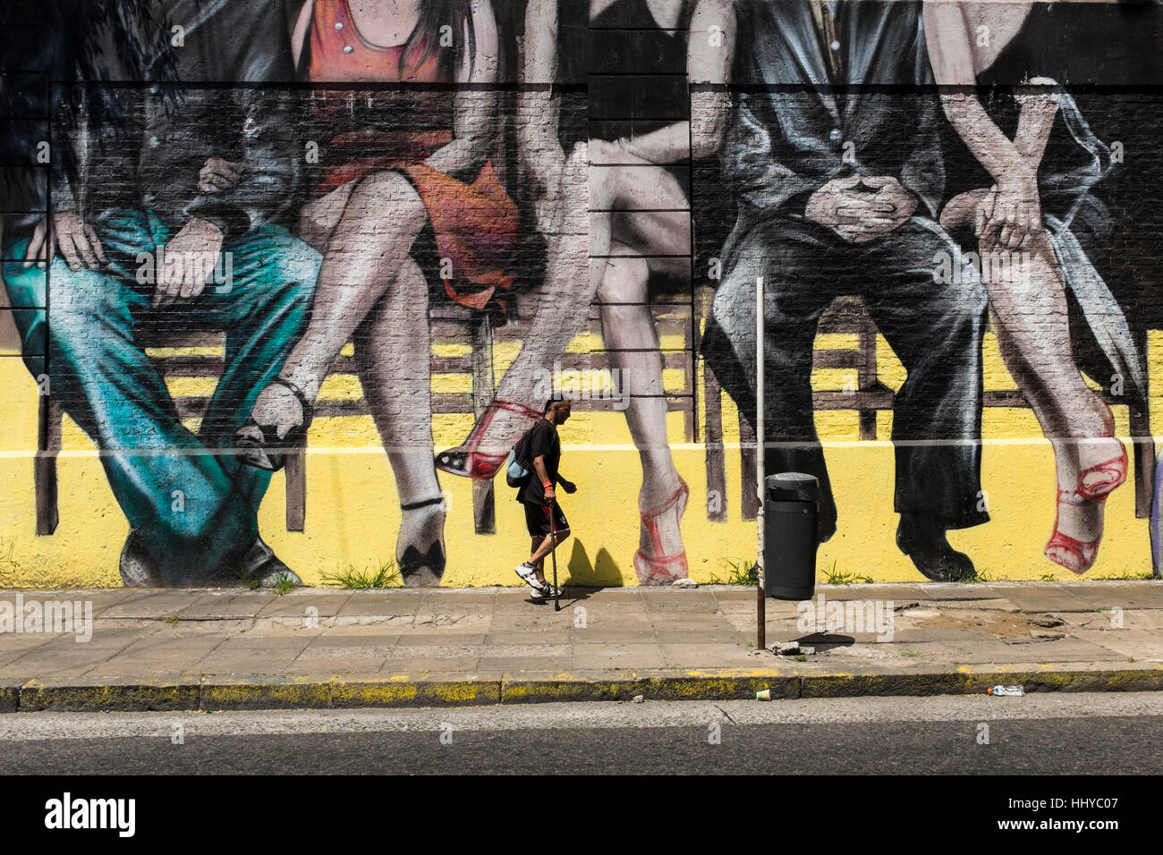 Walking past a city mural depicting sitting couples, Buenos Aires city, Argentina Stock Photo