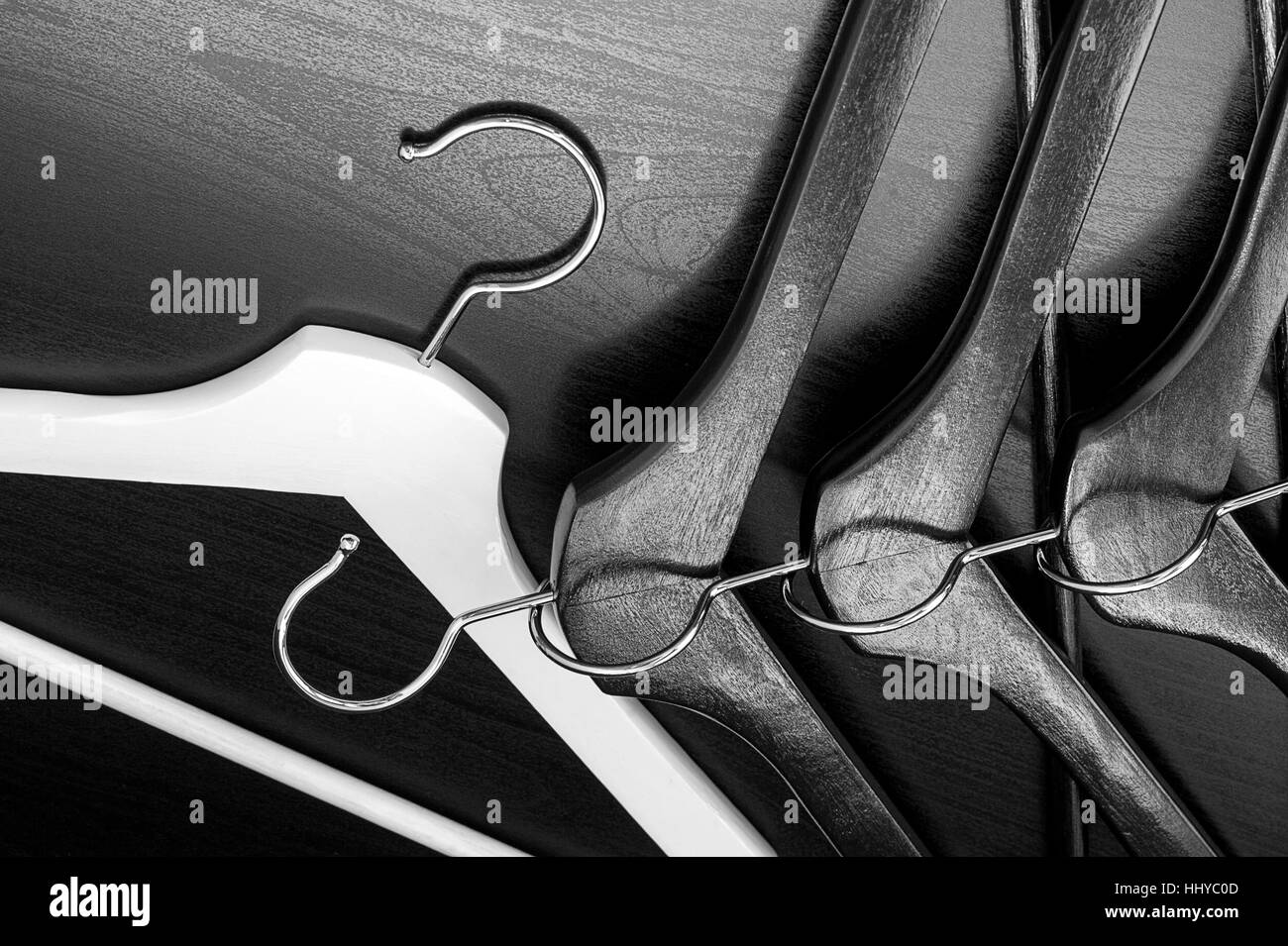 White hanger and a few black hangers, black background, abstract Stock Photo