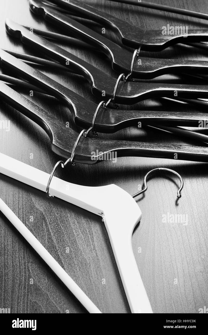 White hanger and a few black hangers, black background, abstract Stock Photo