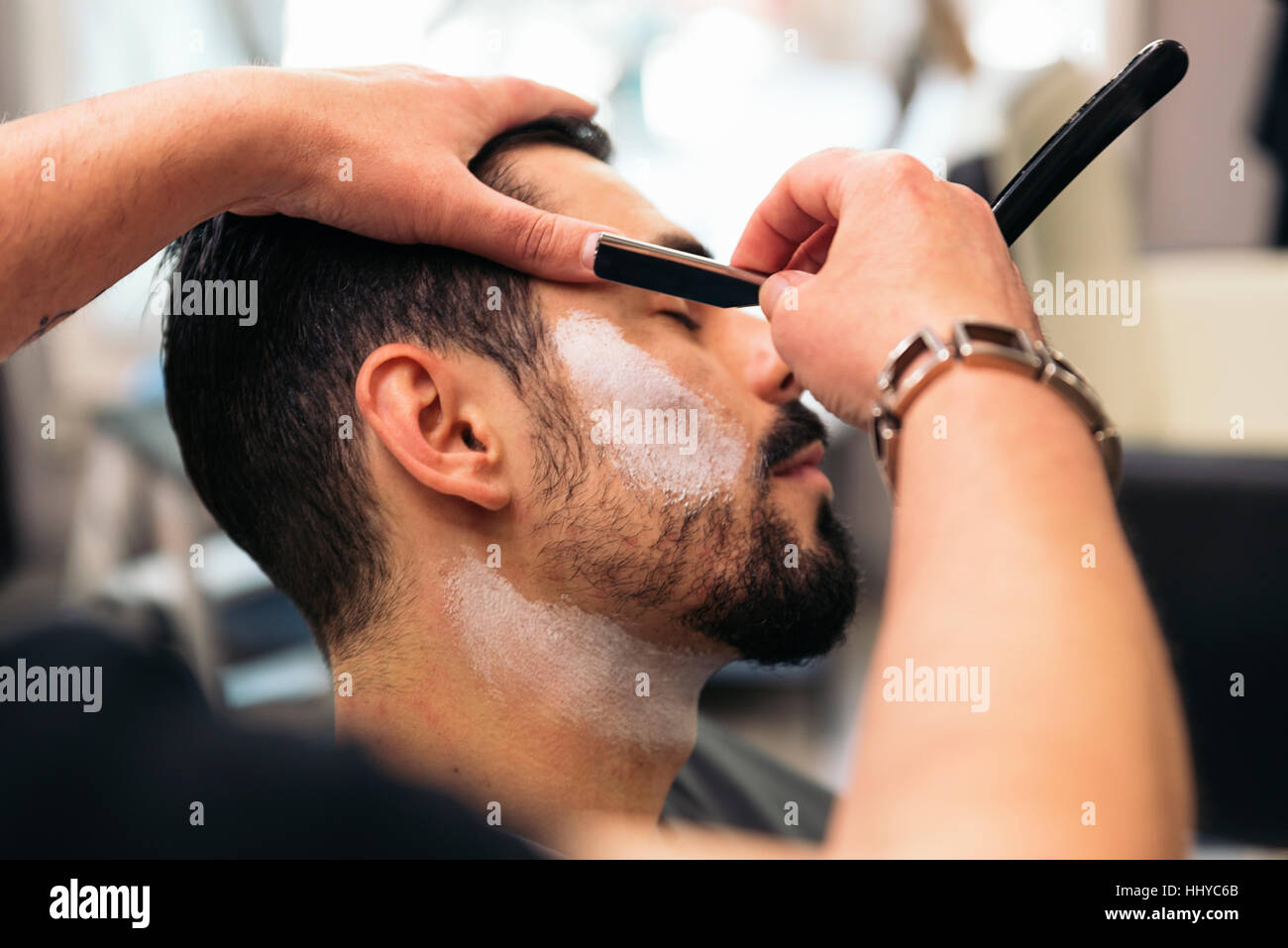 Young Bearded Man Getting Beard Haircut With A Razor By
