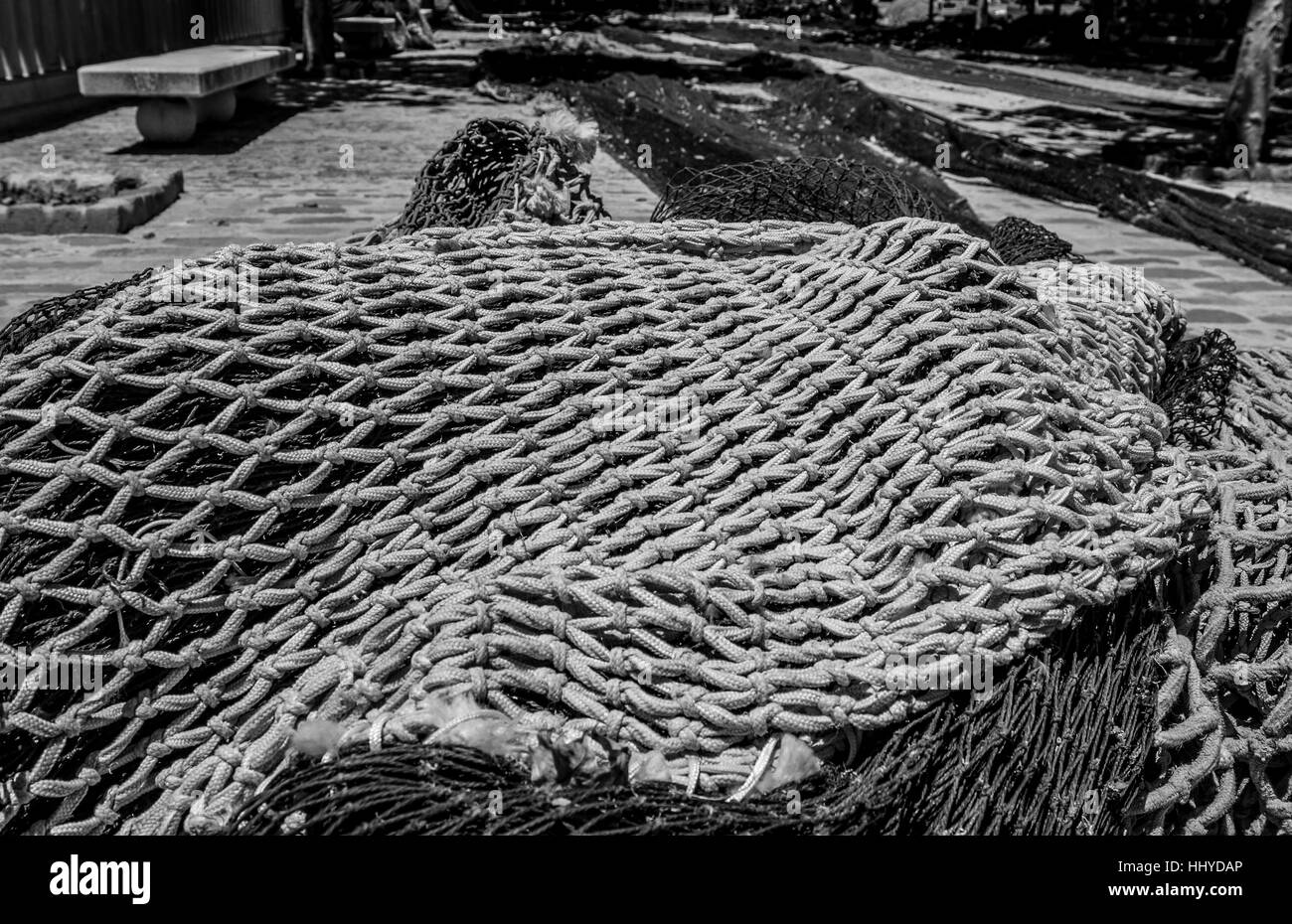 large fishing nets drying on stone path with knots Stock Photo