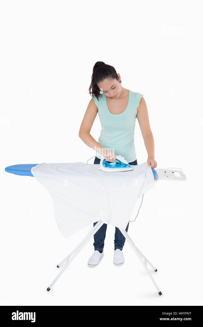 Brunetter ironing white shirt on ironing board Stock Photo