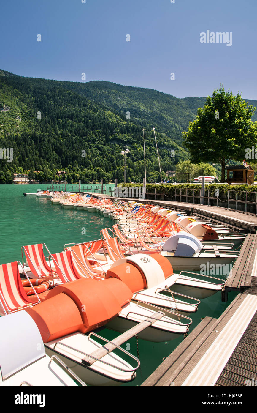 Pedal boat parked in a long line at the dock of the lake Stock Photo