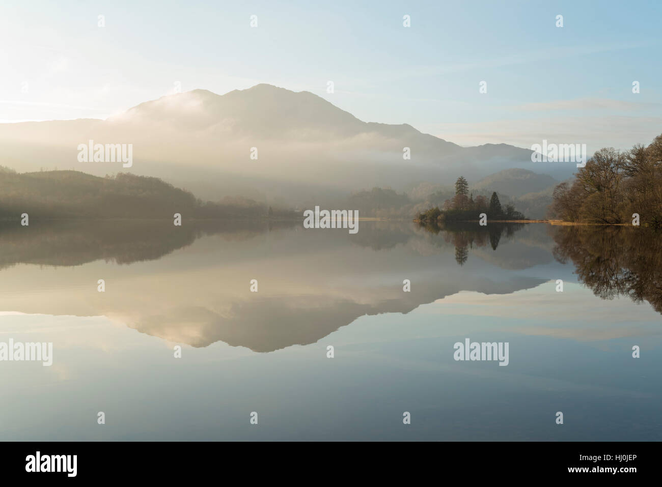 Stirlingshire, Scotland, UK. 21st January, 2017. Loch Achray in Loch Lomond and The Trossachs National Park, Scotland UK, Saturday 21st January 2017 UK weather: High pressure brings misty conditions to Loch Achray with Ben Venue mountain emerging from the clouds. Credit: Aidan Maccormick/Alamy Live News. Stock Photo