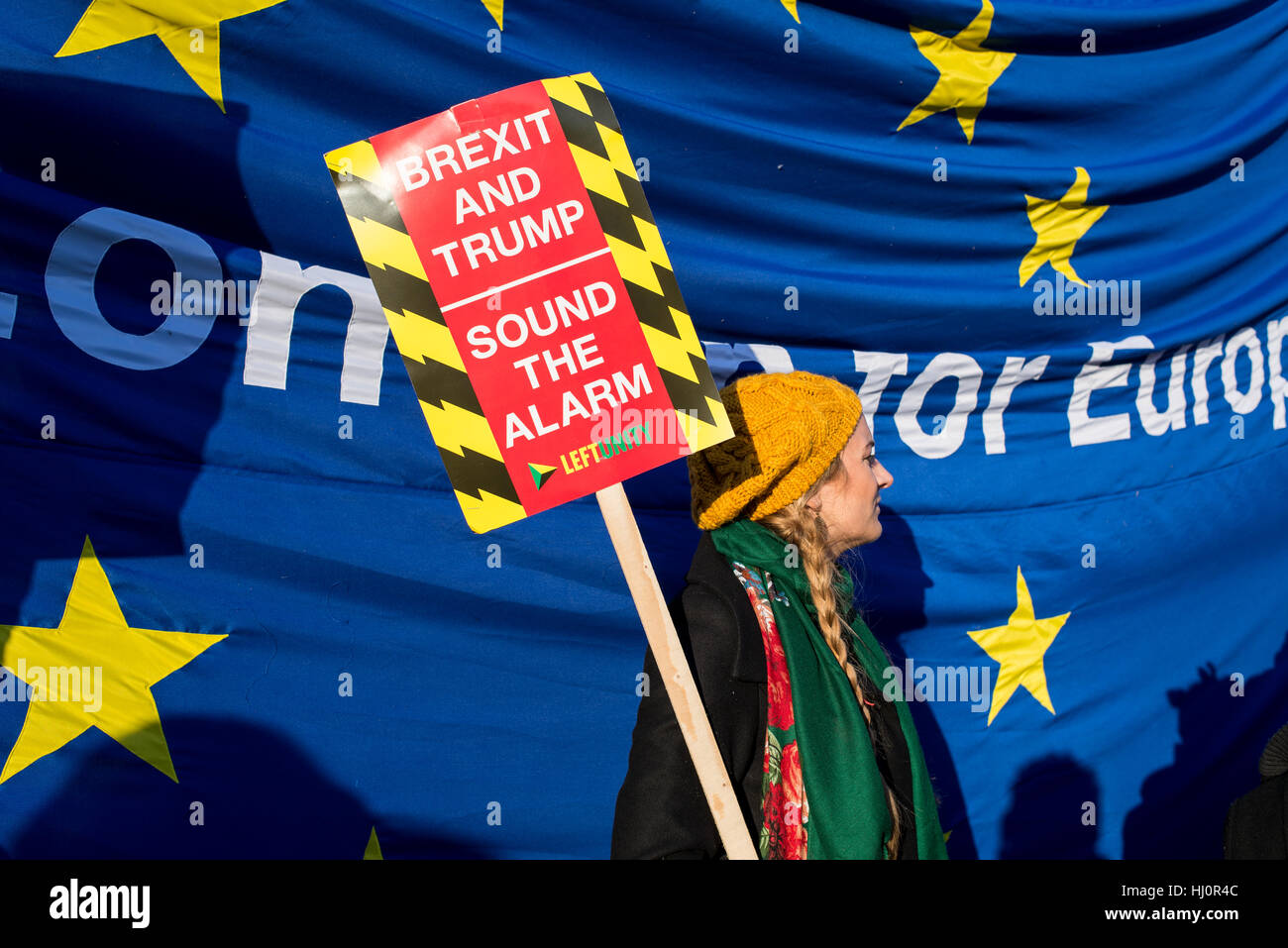 London, UK - 21 January 2017. Protesters holding anti brexit and anti Trump sign standing in front of EU flag.Thousands of protesters gathered in Trafalgar Square to attend Women's March against Donald Trump calling for human rights and equality. Stock Photo