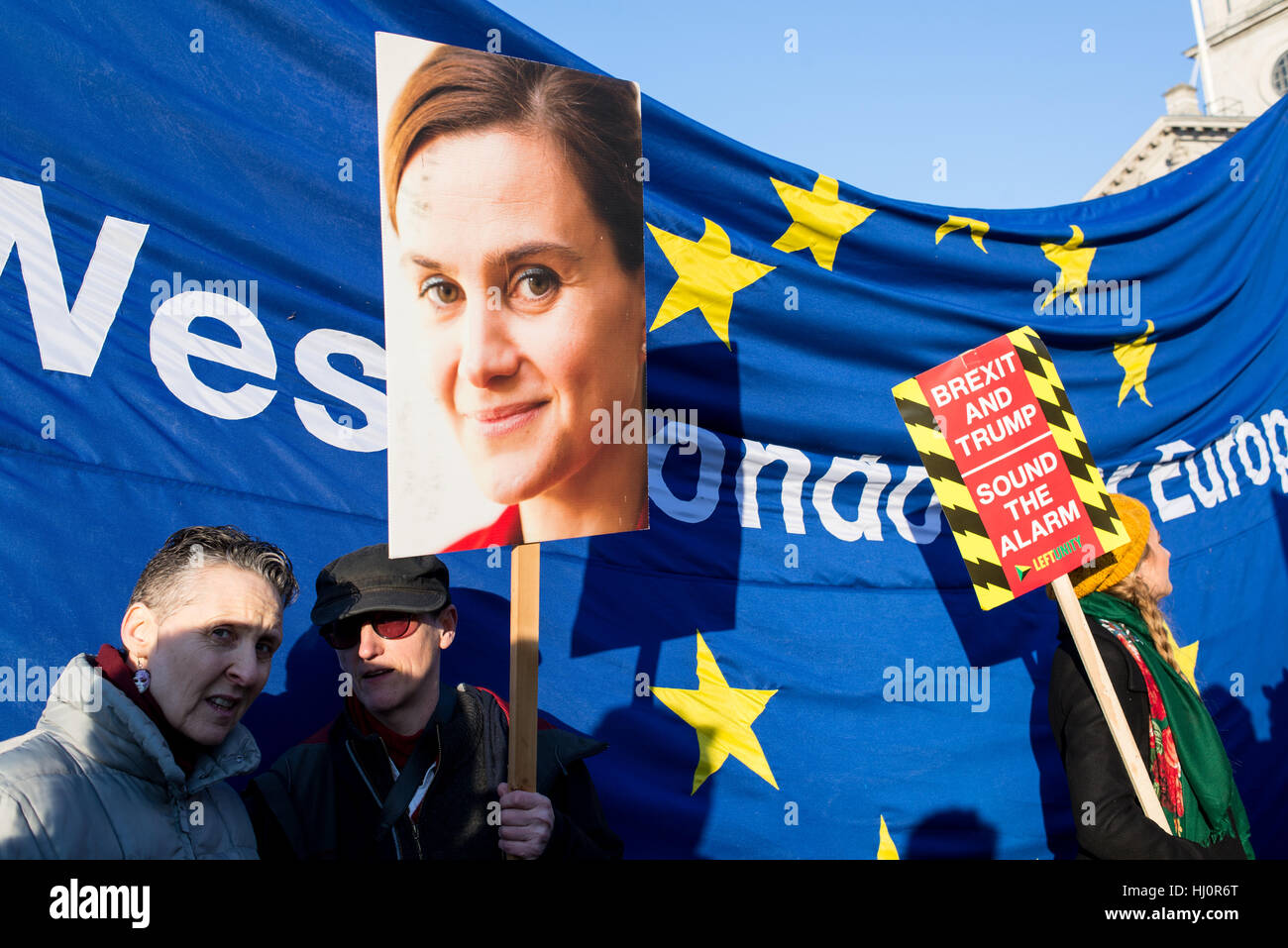 London, UK - 21 January 2017. Protesters holding Jo Cox poster and anti brexit sign standing in front of EU flag.Thousands of protesters gathered in Trafalgar Square to attend Women's March against Donald Trump calling for human rights and equality. Stock Photo