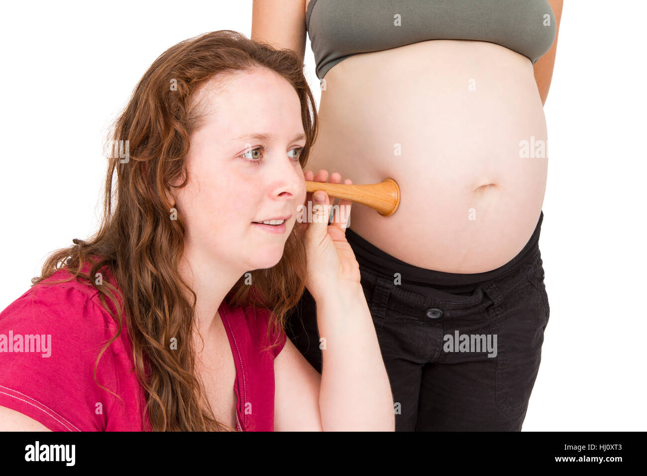 midwife listening at human belly Stock Photo