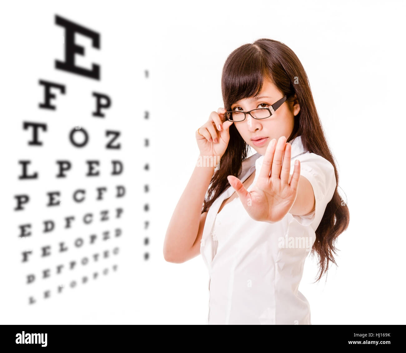 Chinese woman showing no with hand next to eyesight test chart Stock Photo