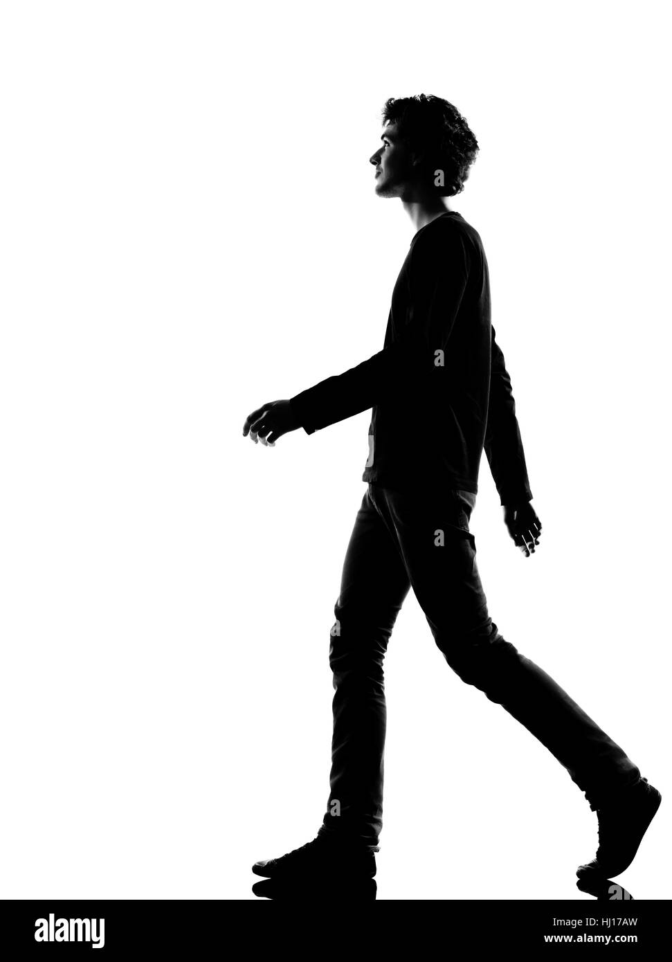 young man walking silhouette in studio isolated on white background ...