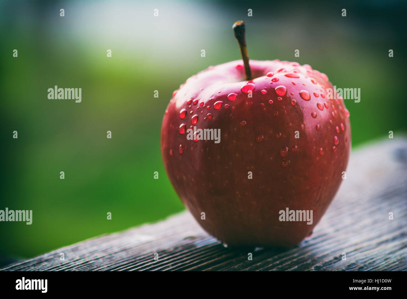 Red apple on wooden table in garden Stock Photo