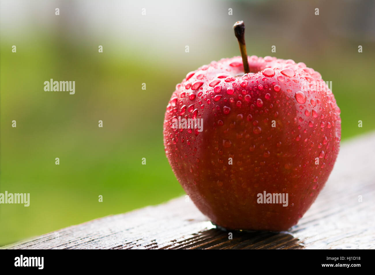 Red apple on wooden table in garden Stock Photo