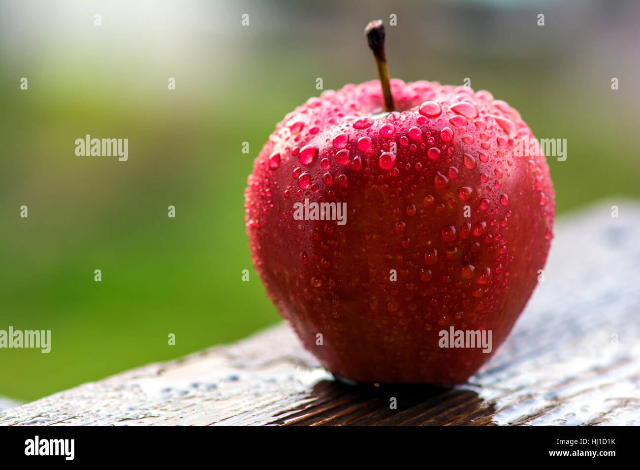 Red apple on wooden table in garden Stock Photo