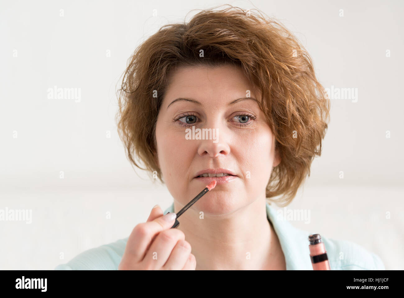 Woman paints her lips at home Stock Photo