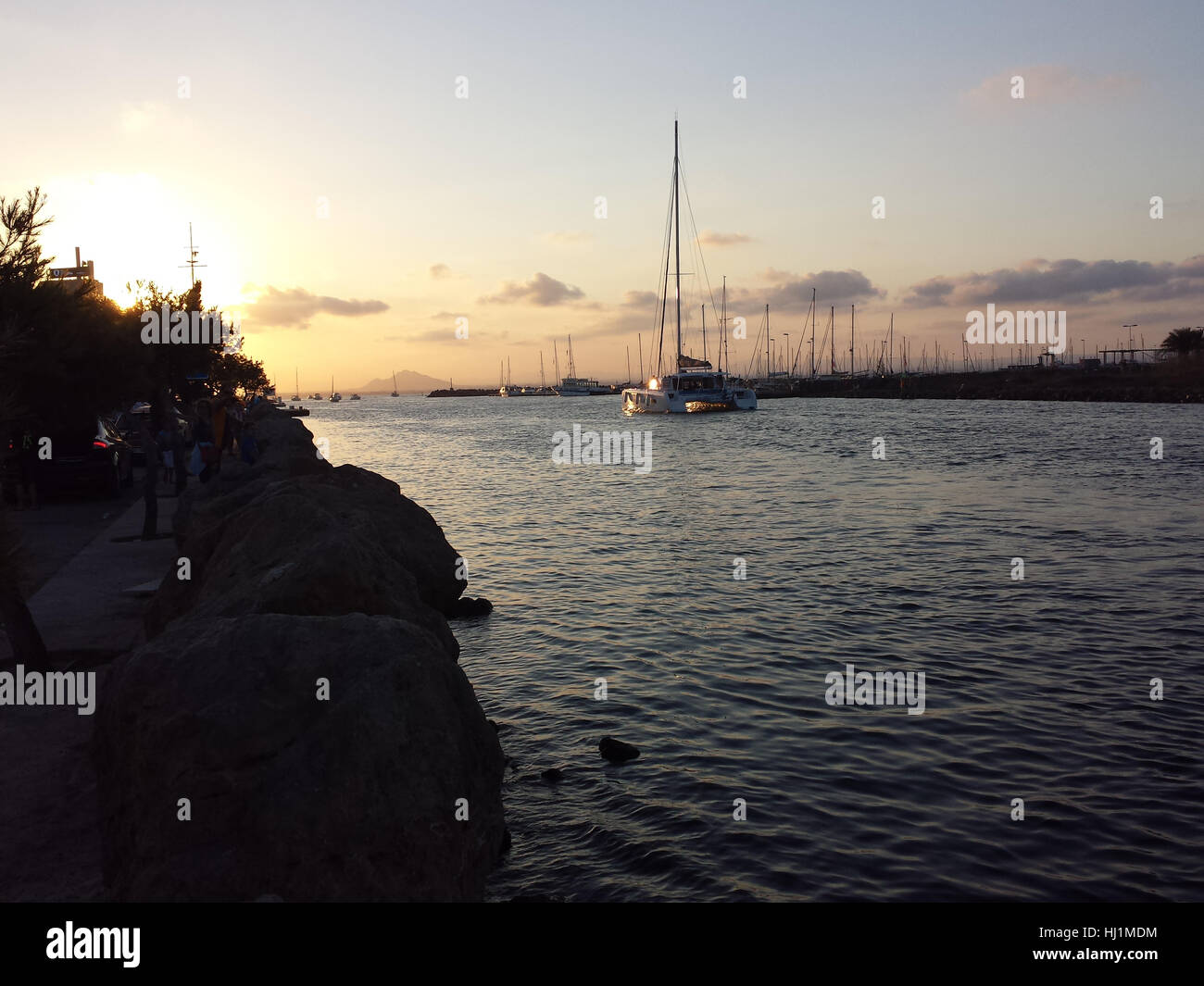 Sailing ships in port at sunset with red sky Stock Photo - Alamy