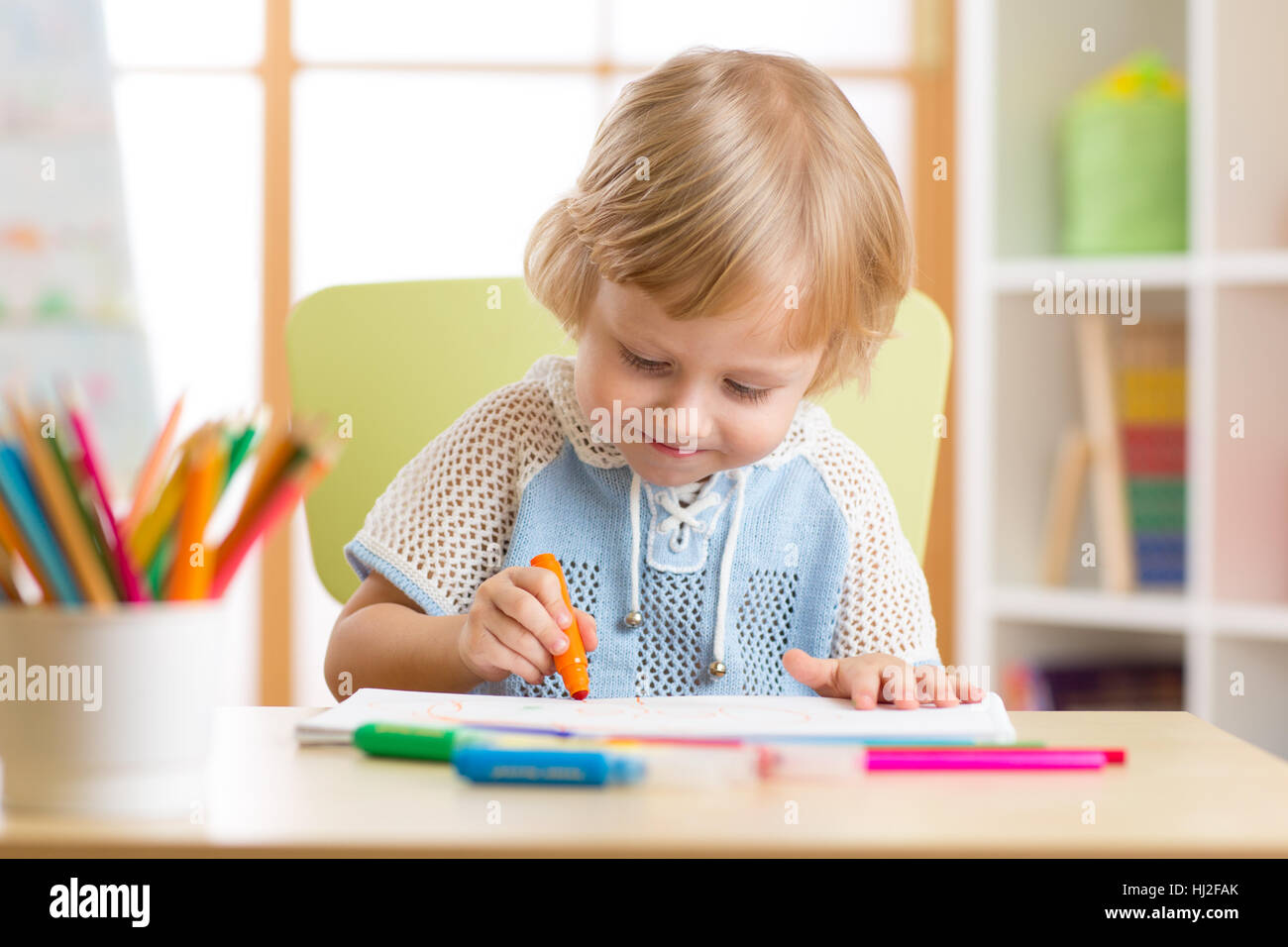 Cute child boy is drawing with felt-tip pen in preschool Stock Photo