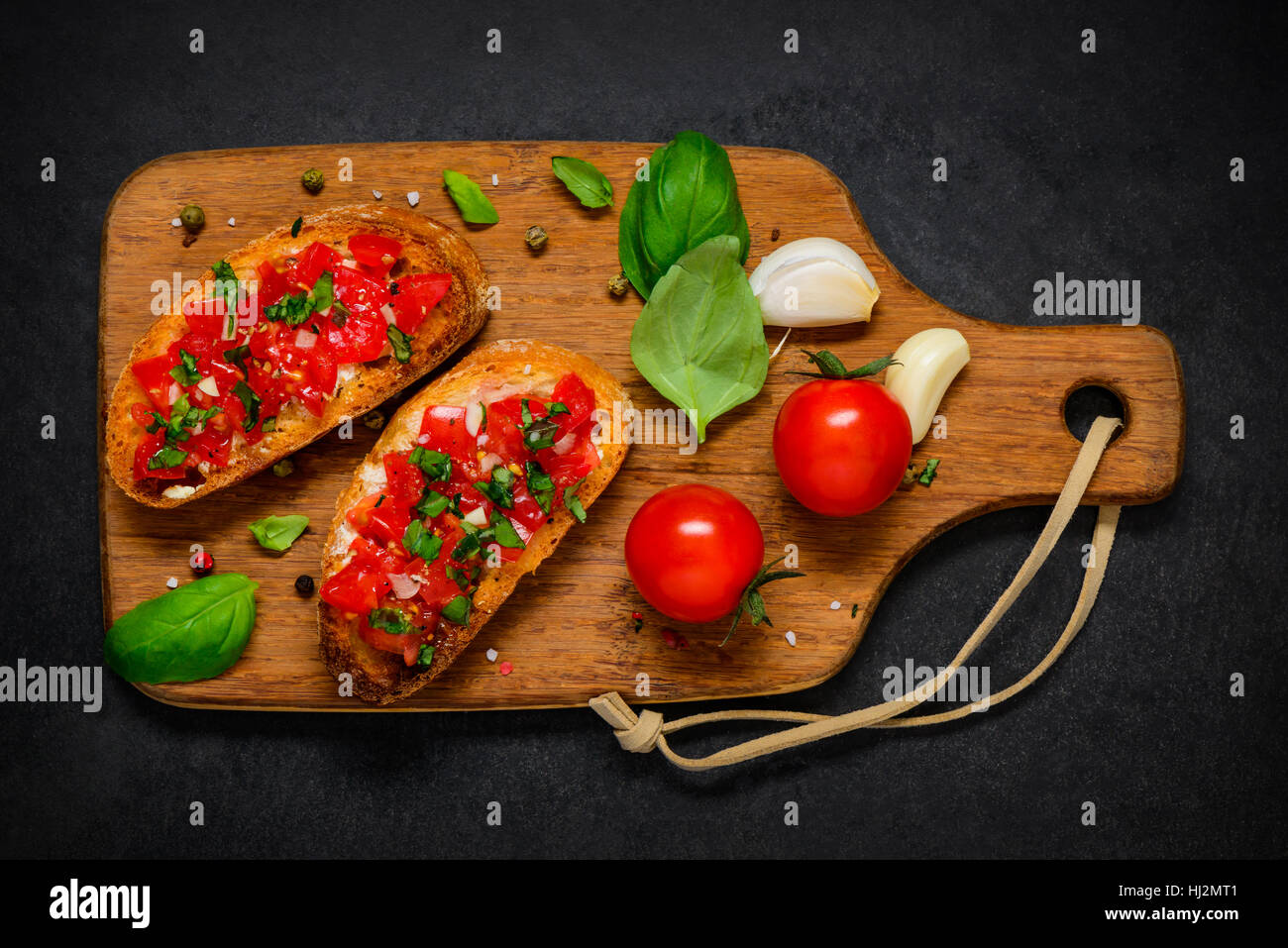 Bruschetta Italian Antipasto with Fresh Tomato and Basil on Wooden Chopping Board Stock Photo