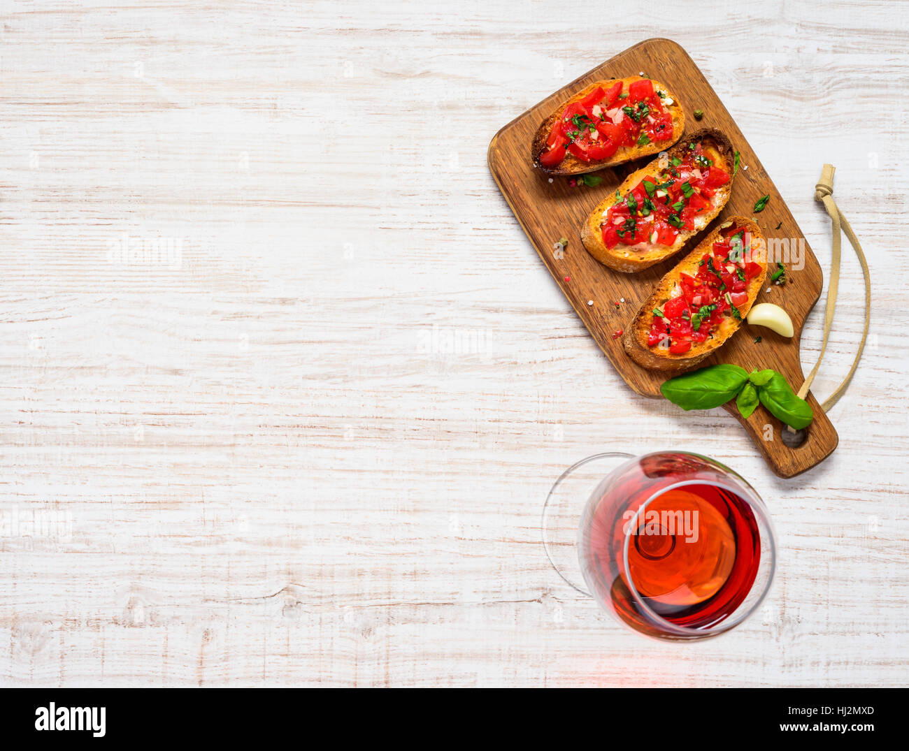 Italian Starter Dish Bruschetta with Tomato and Basil with Glass of Rose Wine on Copy Space Area Top View Stock Photo