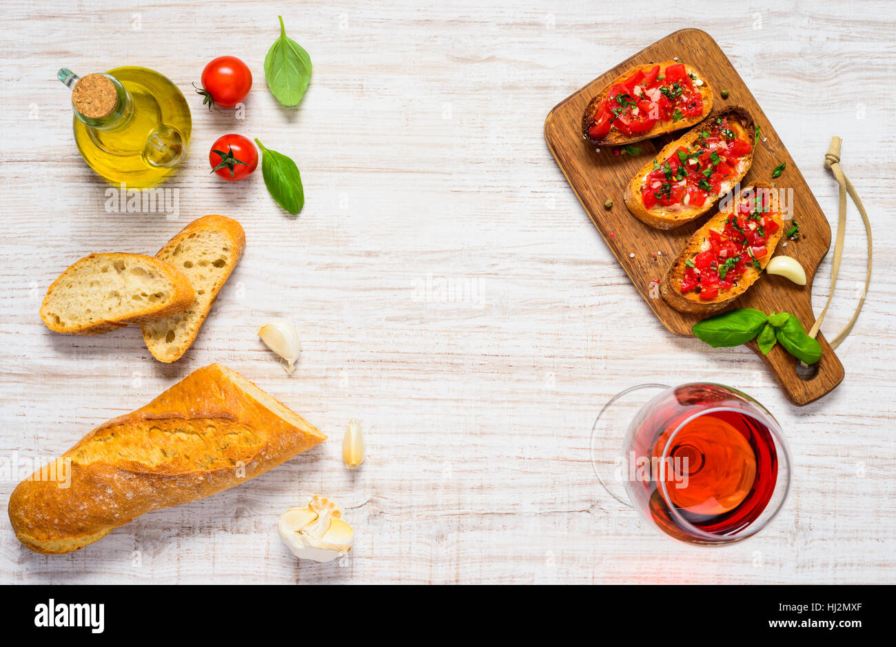 Italian Antipasto Bruschetta with French Bread, Tomato, Basil and Rose Wine in Top View on Copy Space Text Area Stock Photo