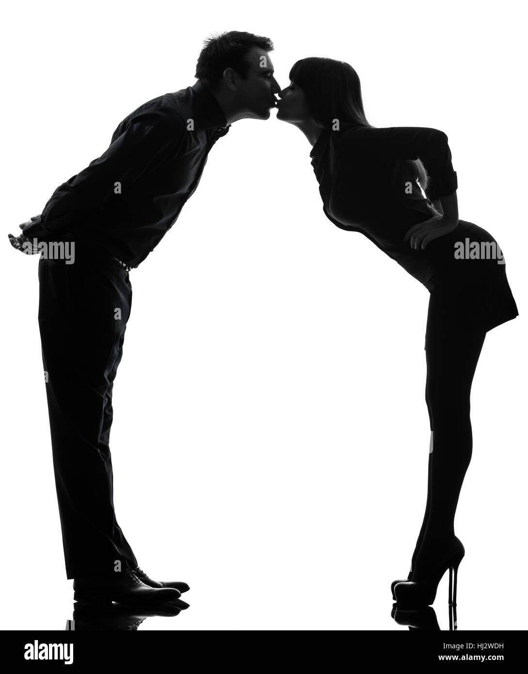 one caucasian couple woman man kissing full length  in silhouette studio isolated on white background Stock Photo