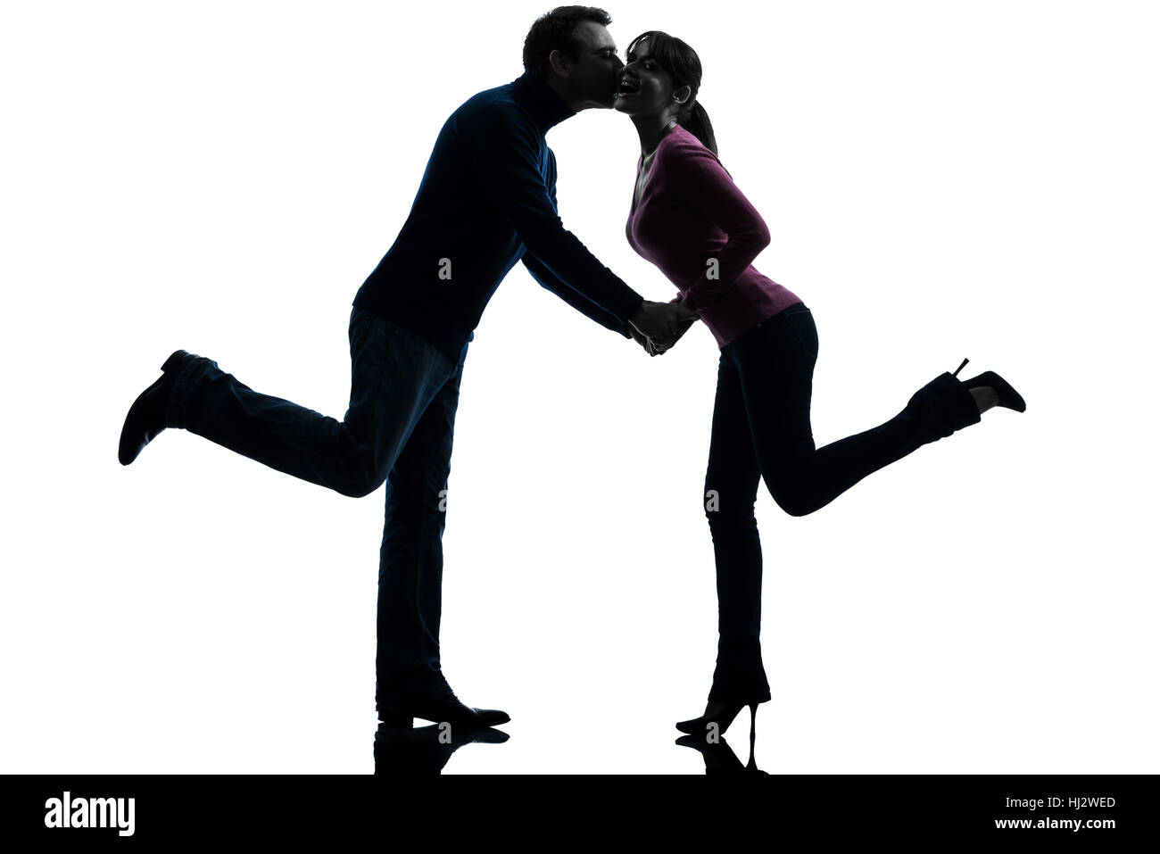 one caucasian couple woman man lovers kissing    in silhouette studio isolated on white background Stock Photo