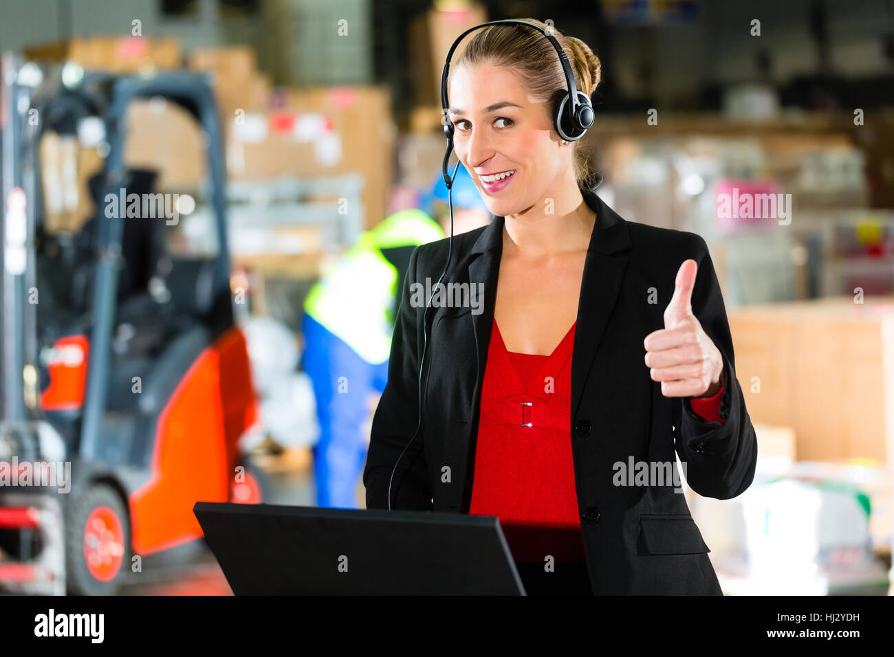 woman with headset in a warehouse spedition Stock Photo