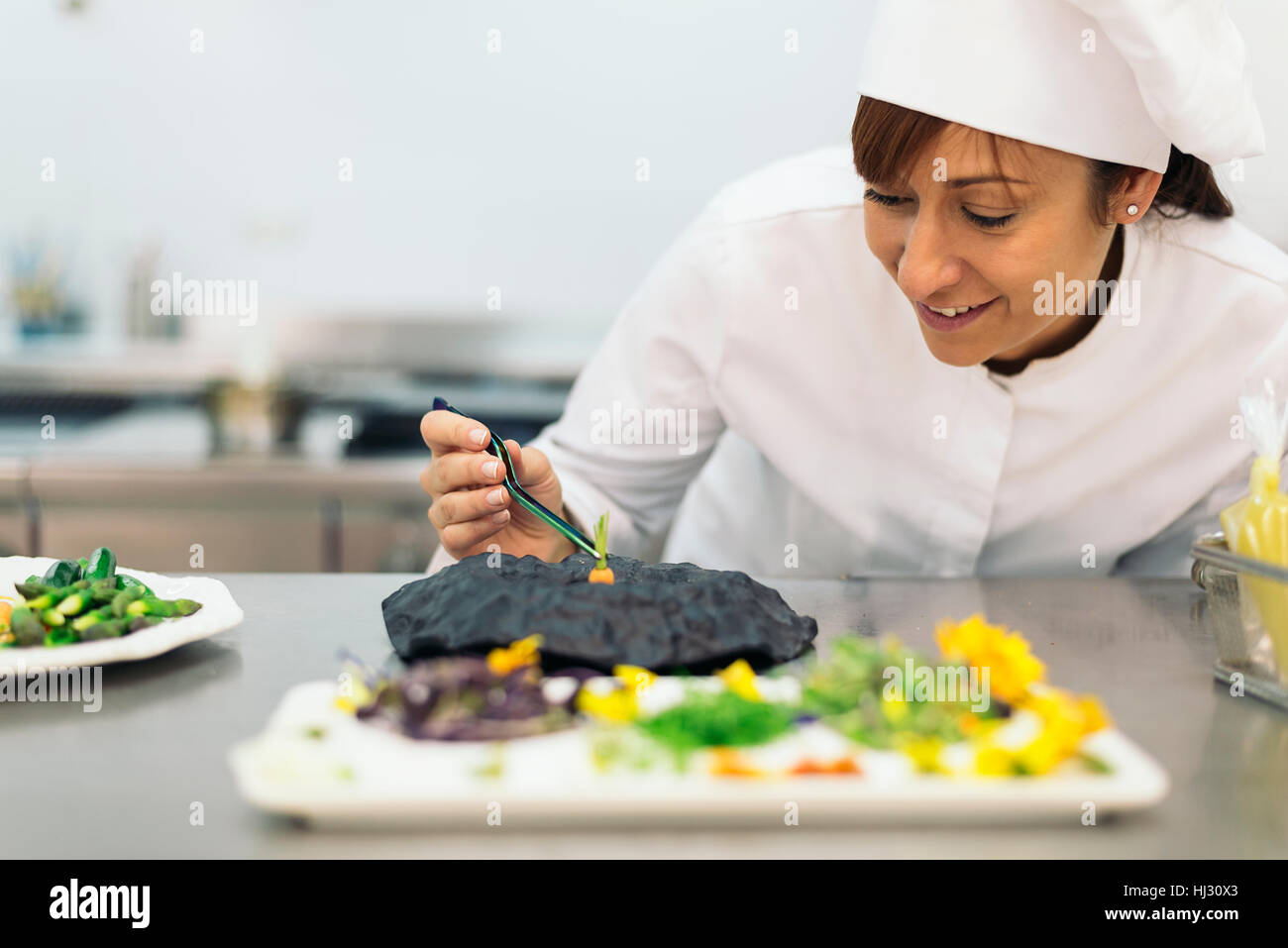 Pretty professional chef cooking in a kitchen Stock Photo - Alamy