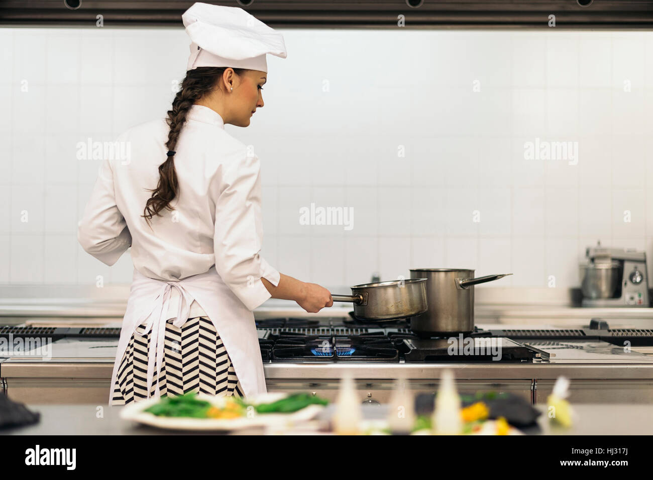 Pretty professional chef cooking in a kitchen Stock Photo - Alamy