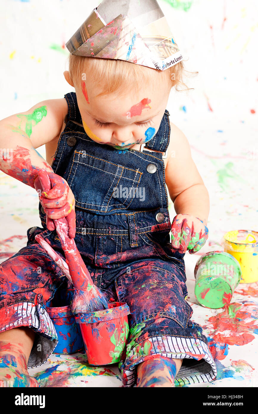 sweet little child in overalls with brushes and colors Stock Photo Alamy