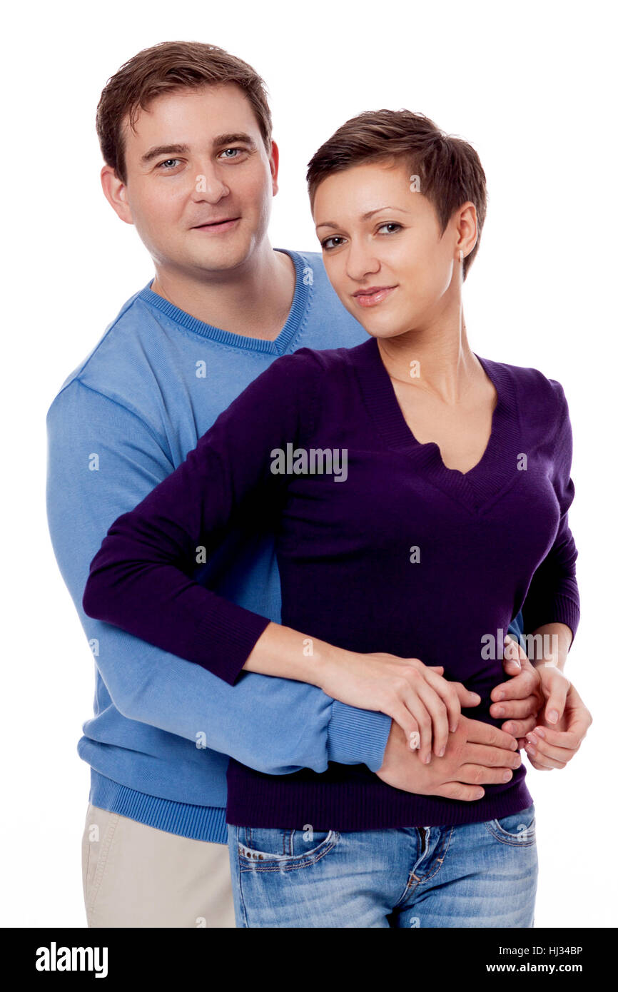 young couple in amorous embrace with blue sweater isolated against white background Stock Photo