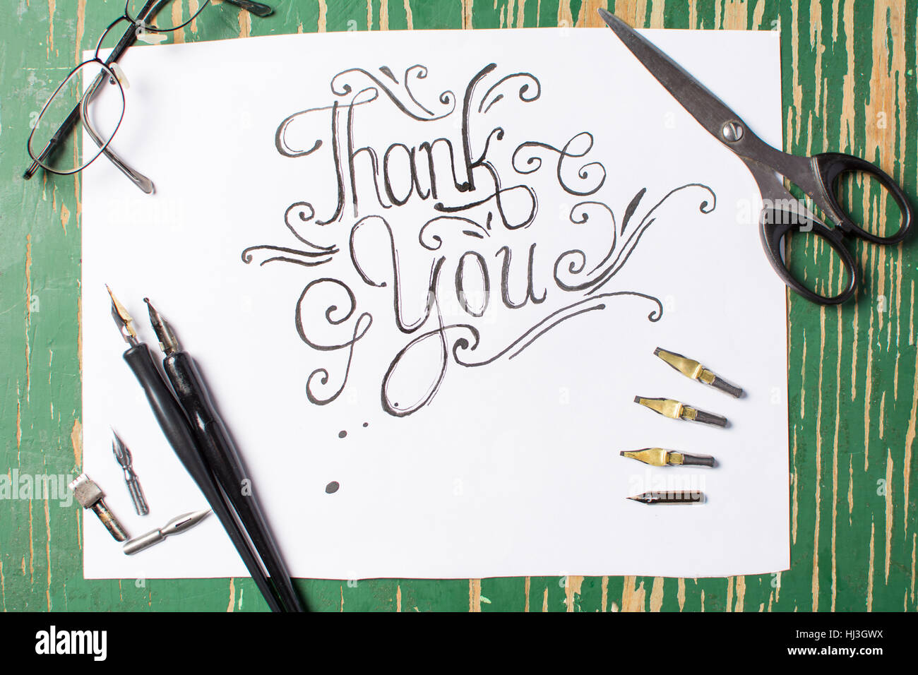 Thank you note calligraphy with writing equipment on the table Stock Photo